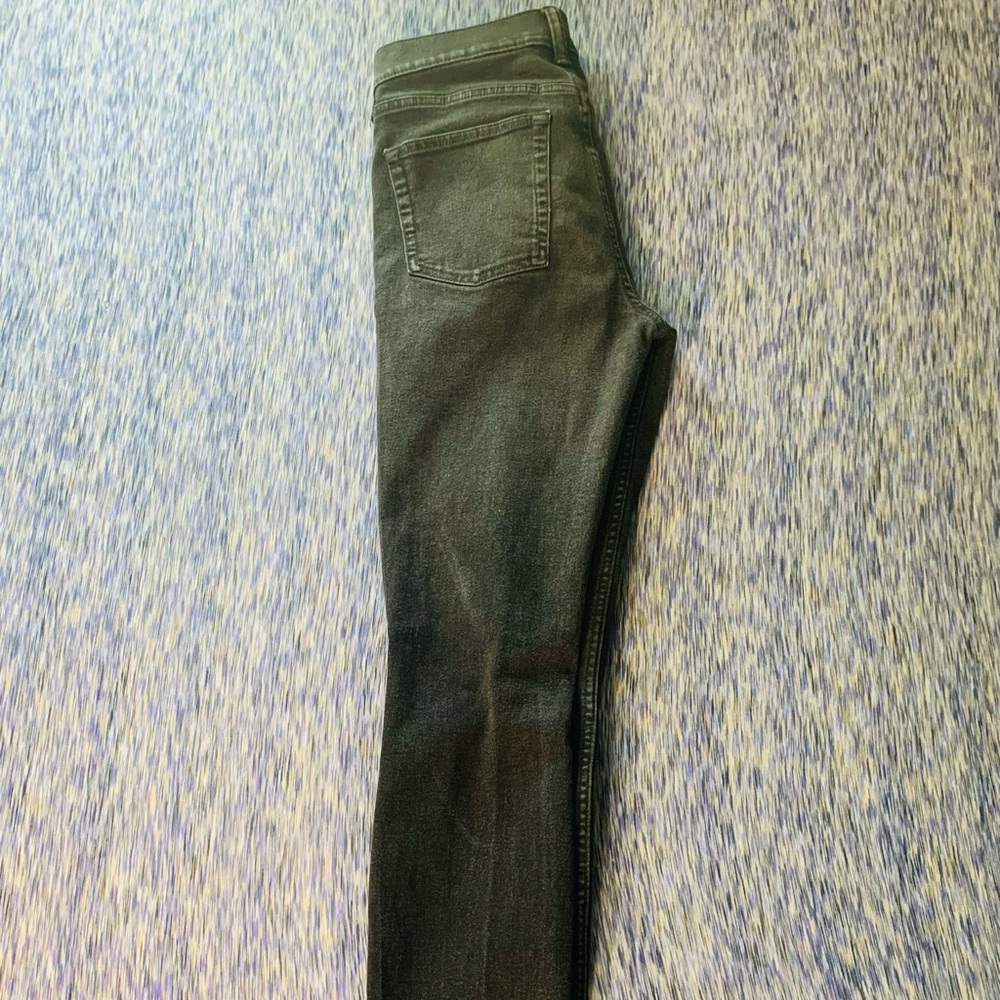 Faded black jeans with one knee rip.